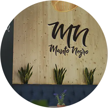 Logotipo de Manto Negro en la pared de madera del restaurante